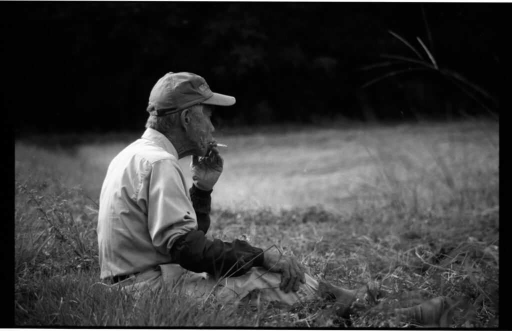 Oratnir・別府倫太郎による祖父を撮ったモノクロフィルム写真作品。稲刈りの合間に畦道で休憩しているところ。撮影場所:新潟県十日町市 使用カメラ：[Nikon New FM2]、フィルム：[ ILFORD HP5 PLUS 400]